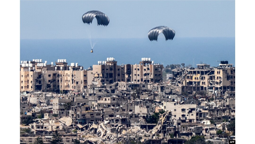 This picture taken from Israel's southern border with the Gaza Strip shows parachutes of humanitarian aid dropping over the besieged Palestinian territory on March 26, 2024, amid the ongoing conflict between Israel and the militant group Hamas.