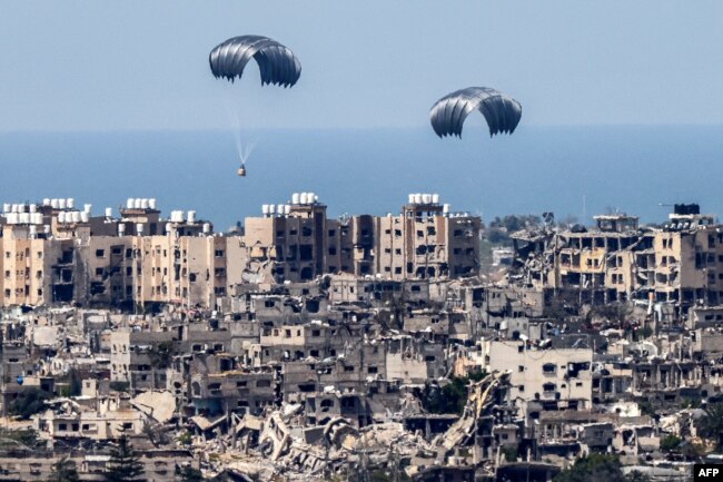 This picture taken from Israel's southern border with the Gaza Strip shows parachutes of humanitarian aid dropping over the besieged Palestinian territory on March 26, 2024, amid the ongoing conflict between Israel and the militant group Hamas.
