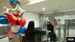 Edeitys Elian Coto Sierra abraza a su hermano, Maikel Antonio Coto Salazar, de Cuba, quien llegó a Miami luego de obtener parole humanitario, el viernes 17 de marzo de 2023, en el Aeropuerto Internacional de Miami. Foto: Alexia Fodere para Voz de América.