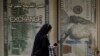 FILE - An Egyptian woman walks past an exchange office in Cairo, Egypt, March 6, 2024. 