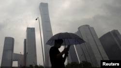 2023年7月12日，中国北京雨天，一名男子行走在中央商务区。（路透社照片）