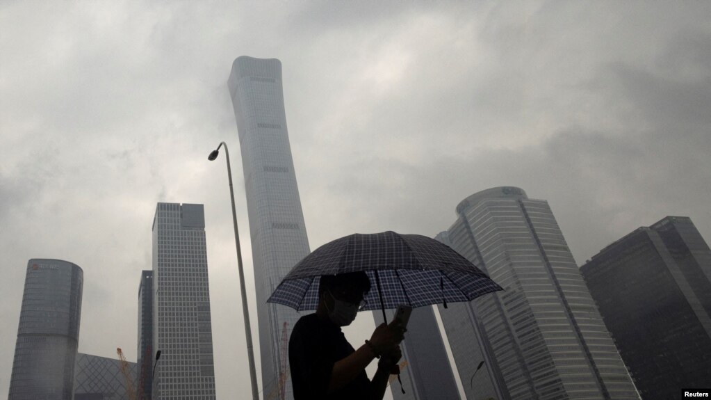 2023年7月12日，中国北京雨天，一名男子行走在中央商务区。（路透社照片）(photo:VOA)