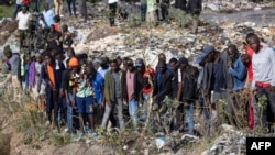 Onlookers gather at the dumpsite where six bodies were found in the landfill in Mukuru slum, Nairobi, on July 12, 2024. 