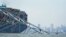 The Baltimore city skyline is visible behind a cargo ship that is stuck under part of the structure of the Francis Scott Key Bridge after the ship hit the bridge, March 26, 2024, in Baltimore.