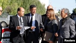 A woman member of Tunisia's new parliament stands at a security checkpoint as the parliament, elected in December and January in a vote with ultra-low turnout, holds its first session, in Tunis, March 13, 2023.