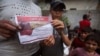 Los palestinos sostienen folletos arrojados por aviones israelíes instándolos a evacuar antes de una operación militar israelí en Rafah, al sur de la Franja de Gaza, el lunes 6 de mayo de 2024. 