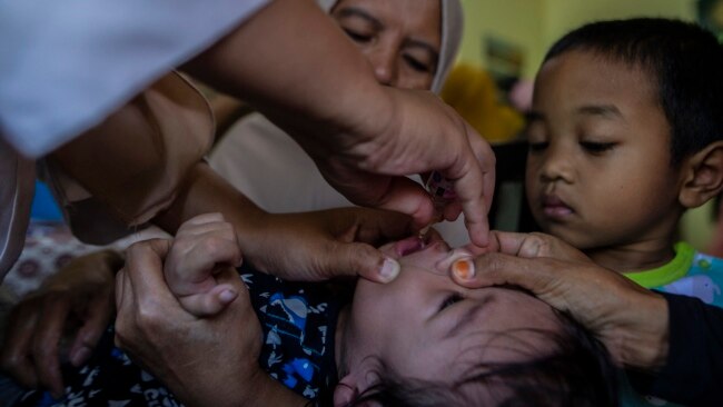 FILE - A health worker gives a polio vaccine to a child in Bogor, West Java, Indonesia, on April 3, 2023.