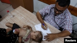 A Palestinian girl is examined by a doctor amid fears over the spread of polio after the first case was reported by the Ministry of Health, at Al-Aqsa Martyrs Hospital, in Deir Al-Balah in the central Gaza Strip, Aug. 18, 2024. 