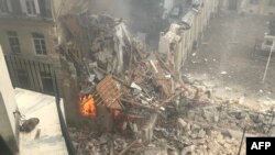 This photograph taken on June 21, 2023, shows the flames emerging from the destruction and rubble in the immediate aftermath of an explosion in a building on Rue Saint-Jacques near Place Alphonse-Laveran in the 5th arrondissement of Paris.