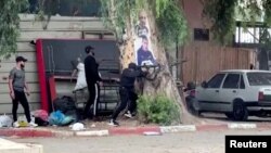 ইসরাইল অধিকৃত পশ্চিম তীরের জেনিনে তল্লাশির সময় ইসরাইলি সেনার সঙ্গে সংঘর্ষ চলাকালে এক ফিলিস্তিনি বন্দুকধারী গুলি ছুঁড়ছে। ১৯ জুন, ২০২৩। ভিডিও থেকে এই স্থিরচিত্রটি নেওয়া হয়েছে। (রয়টার্স/রনিন সাওয়াফতা)