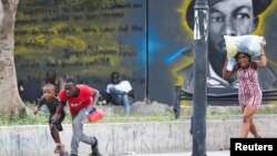 People take cover from gunfire near the National Palace, in Port-au-Prince, Haiti, March 21, 2024. 