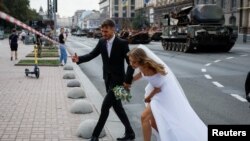 Una pareja de recién casados visita una exposición de tanques rusos destruidos por las tropas ucranianas en Kiev, el 21 de agosto de 2023.