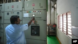 (FILE) Electrician checks the parameter of output breaker of 500 KW Battery Energy storage system inside the Hindustan Coca-Cola Beverages factory in Thiruvallur district, on the outskirts of Chennai, India, Tuesday, July16, 2024.