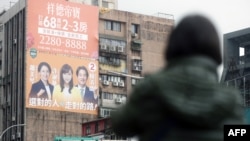 An election campaign billboard showing Taiwan's ruling Democratic Progressive Party presidential candidate Lai Ching-te, right, his running mate Hsiao Bi-khim, left, and legislative candidate Hsu Shu-Hua is seen on a building in Taipei on Dec. 28, 2023.