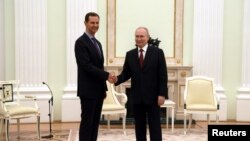 블라디미르 푸틴(오른쪽) 러시아 대통령과 바샤르 알아사드 시리아 대통령이 15일 크렘린궁에서 악수하고 있다. 