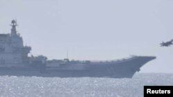 日本防衛省提供的畫面顯示2023年4月10日戰機飛離中國山東號航母的照片。