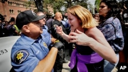 A University of Southern California protester, right, confronts a University Public Safety officer at the campus' Alumni Park during a pro-Palestinian occupation in Los Angeles, California, April 24, 2024.
