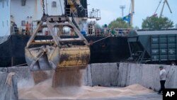 Workers load grain at a grain port in Izmail, Ukraine, April 26, 2023.