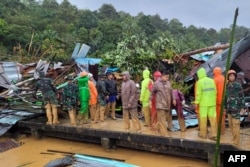 Tim SAR memeriksa kerusakan akibat tanah longsor di kepulauan Natuna, 7 Maret 2023. (Handout / Kemenkominfo Natuna / AFP)