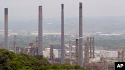 FILE - Chimneys from the Shell oil company release gases on the outskirts of the city of Durban, South Africa on Wednesday, Nov. 30, 2011. 