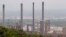 FILE - Chimneys from the Shell oil company release gases on the outskirts of the city of Durban, South Africa on Wednesday, Nov. 30, 2011. 