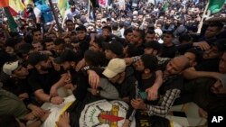 Palestinian mourners carry the body of Iyad al-Hassani, an Islamic Jihad commander, draped in the militant group's flag, during his funeral in Gaza City, May 13, 2023.