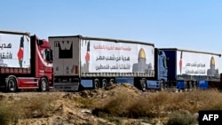 FILE - Egyptian trucks carrying humanitarian aid bound for the Gaza Strip wait near the Rafah border crossing on the Egyptian side on March 23, 2024.