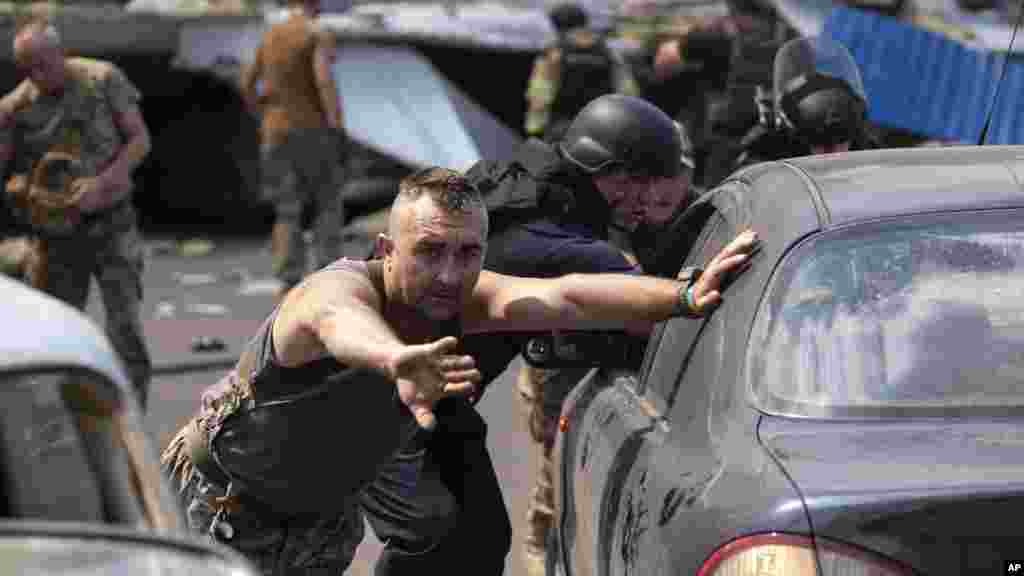 Emergency workers and soldiers push a damaged cars after a Russian missile hit a supermarket in Kostiantynivka, Donetsk region, Ukraine.