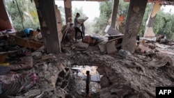 Palestinos inspeccionan los daños en una casa después de que fuera alcanzada en un ataque israelí en el campamento de al-Bureij, en el centro de la Franja de Gaza, el 3 de junio de 2024.