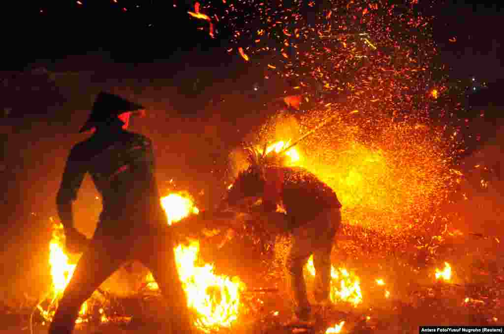 Youths play with sparks and flames from coconuts and banana leaves during a torch battle following a traditional annual event to express gratitude for the harvest and reject reinforcements at Tegalsambi village in Jepara, Central Java province, Indonesia, June 5, 2023.