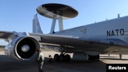 FILE - A NATO officer inspects an aircraft as it prepares to take off for a training mission from an air base in Geilenkirchen, near the German-Dutch border April 16, 2014. 