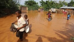 FILE - Children flee floodwaters that wreaked havoc at Mororo, at the border of Tana River and Garissa counties, Kenya, April 28, 2024. 