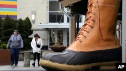 Compradores pasan frente a una gran bota L.L. Bean que se exhibe fuera de una tienda L.L. Bean en Pittsburgh, Pensilvania, el lunes 30 de enero de 2023. (Foto AP/Gene J. Puskar)