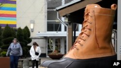 FILE: Shoppers pass an large L.L. Bean boot displayed outside an L.L. Bean store in Pittsburgh on Mon. Jan. 30, 2023. 