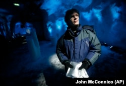 FILE - Cary Fowler holds packets of seeds inside the Svalbard Global Seed Vault, Feb. 25, 2008. (AP Photo/John McConnico)