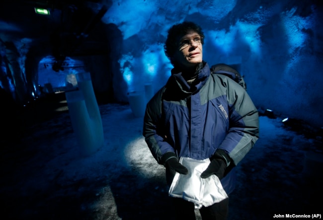 FILE - Cary Fowler holds packets of seeds inside the Svalbard Global Seed Vault, Feb. 25, 2008. (AP Photo/John McConnico)