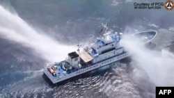 This frame grab from handout video footage taken by the Philippine Coast Guard shows the Philippine Coast Guard ship BRP Bagacay being hit by water cannon from Chinese coast guard vessels near the Scarborough shoal. (Philippine Coast Guard / AFP)