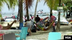 Un grupo de migrantes descansan en carpas en las playas de Necoclí, la localidad colombiana que recibe el mayor número de migrantes en tránsito hacia el Darién. [Foto: Federico Buelvas, VOA]. 