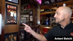 El responsable del bar "Café Prima Pasta" en Miami Beach, Florida, enseña una de las fotografías expuestas en el negocio durante una visita de Leo Messi.