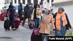 Des migrants se dirigent vers un vol de rapatriement, quittant la Tunisie pour leurs pays d'origine le 4 mars 2023.