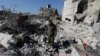 FILE - Naser al-Wakaa stands on the rubble of his home, ruined in the Feb. 6 earthquakes, in the rebel-held town of Jandaris, Syria, Feb. 9, 2023.