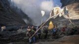 Villagers catch offerings thrown by members of the Tengger sub-ethnic group in the crater of the active Mount Bromo volcano as part of the Yadnya Kasada festival in Probolinggo, East Java province, Indonesia.