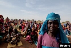 Halime Adam Moussa, a Sudanese refugee, waits with other refugees to receive a food portion from World Food Program in Koufroun, Chad, near the border between Sudan and Chad, May 9, 2023.