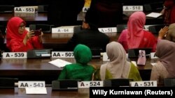 Sejumlah legislator perempuan saling mengabadikan foto saat menghadiri pidato kepresidenan menjelang Hari Kemerdekaan di Gedung DPR/MPR, di Jakarta, 16 Agustus, 2019. (Foto: Willy Kurniawan/Reuters)