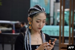资料照：佩戴着蒂芙尼项链的中国时尚网红博主王睿在查看手机。（2019年9月19日）