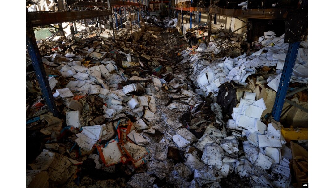 Buku-buku yang terbakar terlihat di bengkel yang rusak di percetakan terbesar Ukraina yang hancur akibat serangan rudal mematikan Rusia yang menewaskan tujuh warga sipil di Kharkiv, Ukraina, 24 Mei 2024. (Foto: via AP)