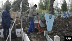 Municipal workers clean a graveyard after a shelling of the central cemetery in the town of Kramatorsk in the region of Donbass during the Russian invasion of Ukraine, April 11, 2023.