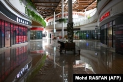 Seorang pria duduk di lorong depan Forest City Outlet Mall yang kosong, sebuah proyek pembangunan yang diluncurkan di bawah Inisiatif Sabuk dan Jalan China di di Johor Malaysia, 1 September 2023. (Foto: AFP/Mohd RASFAN)