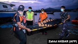 Anggota BASARNAS membawa kantong mayat saat melakukan operasi pencarian pengungsi Rohingya yang hilang di dekat Calang, Aceh Barat, pada 23 Maret 2024. (Foto: AFP/Zahlul AKBAR)