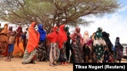 (FILE) Internally displaced Ethiopians queue to receive food aid in a camp for people displaced by drought.